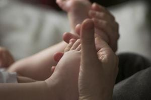 parent holding baby toes and feet in hands