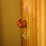 baby's hand sticking out between crib bars