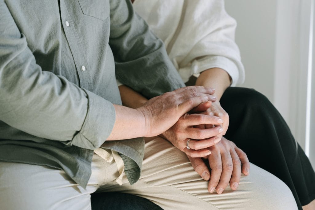 Parkinson’s Tremor Patient holding hands with loved one Parkinson’s patient with tremors holding hands with wife